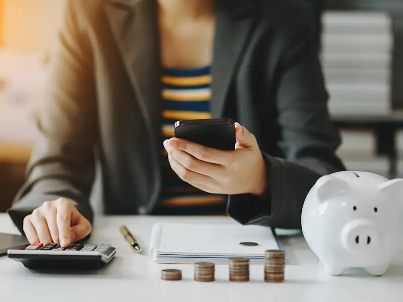 woman holding phone and calculator